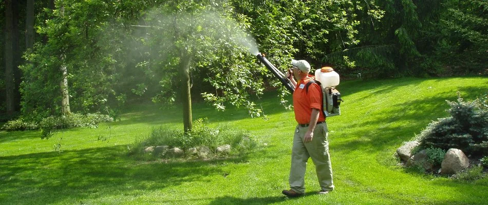 Crew member applying mosquito treatment on a property in Portage, MI.