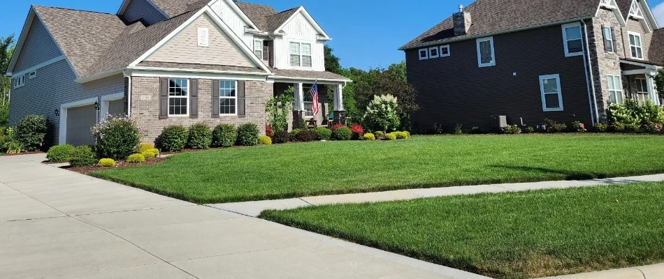 A home's front lawn in Greenville, MI, with green grass.