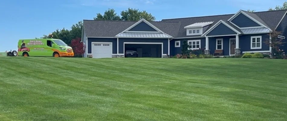Residential property with nice lawn and green van in Coopersville, MI.