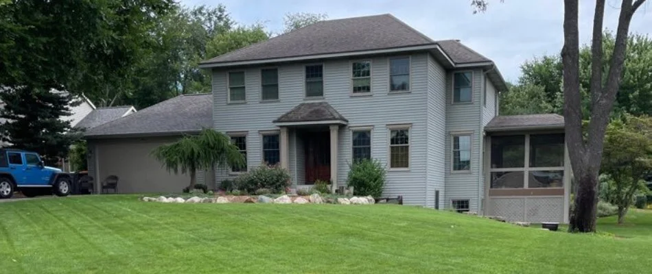 Lawn with blue car in driveway in Dorr Township, MI.