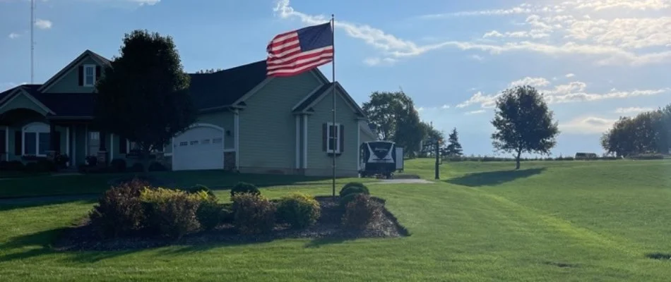 Residential property in Zeeland Charter Township, MI, with flag in landscape bed.