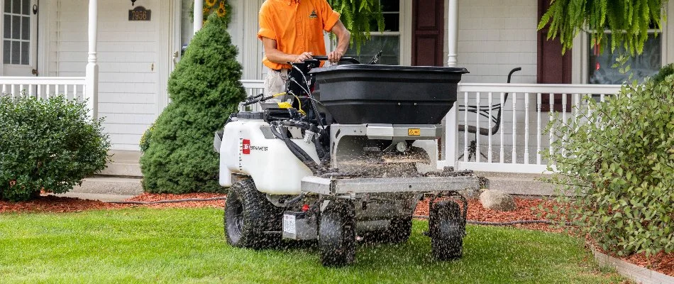 Machinery spreading granular fertilizer across grass in Hastings, MI.