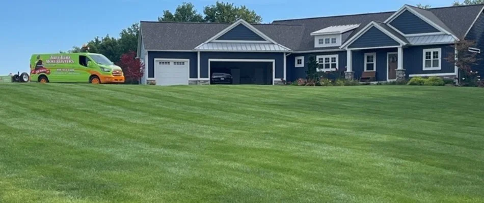 Residential lawn with blue house in Northview, MI.