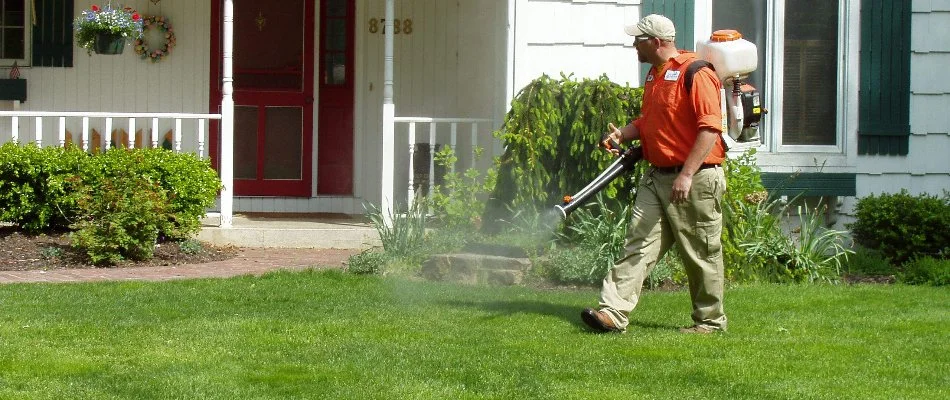 Worker spraying mosquito control treatment on lawn in Conklin, MI.