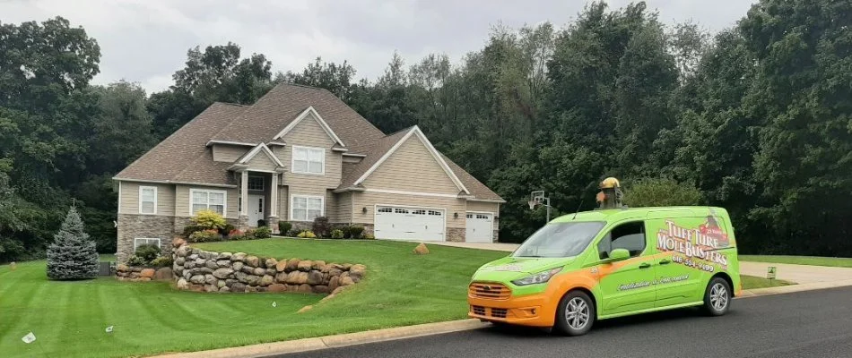 Residential property with green grass and van in street in Portage, MI.