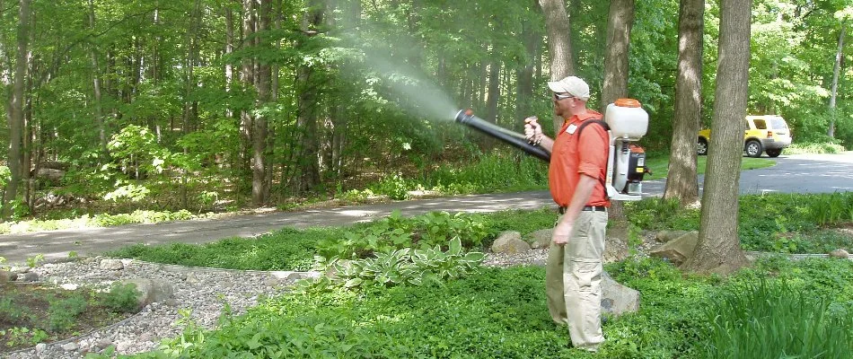Worker spraying mosquito treatment in Hudsonville, MI.