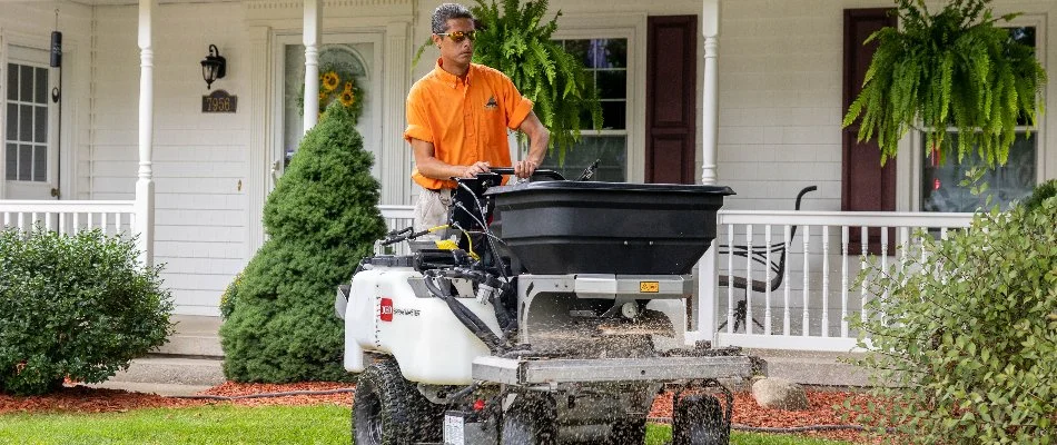 Worker spreading fertilizer on a lawn in Sparta, MI.