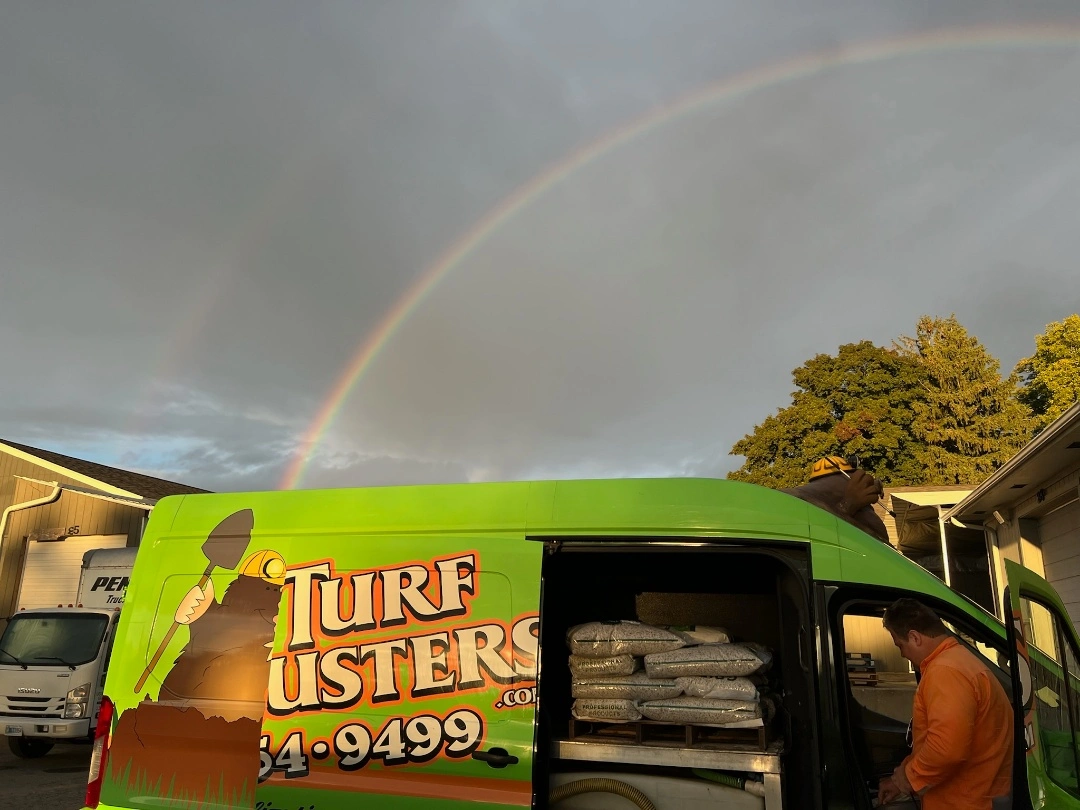 A bright green business vehicle with a rainbow in the background, in Grand Rapids, MI