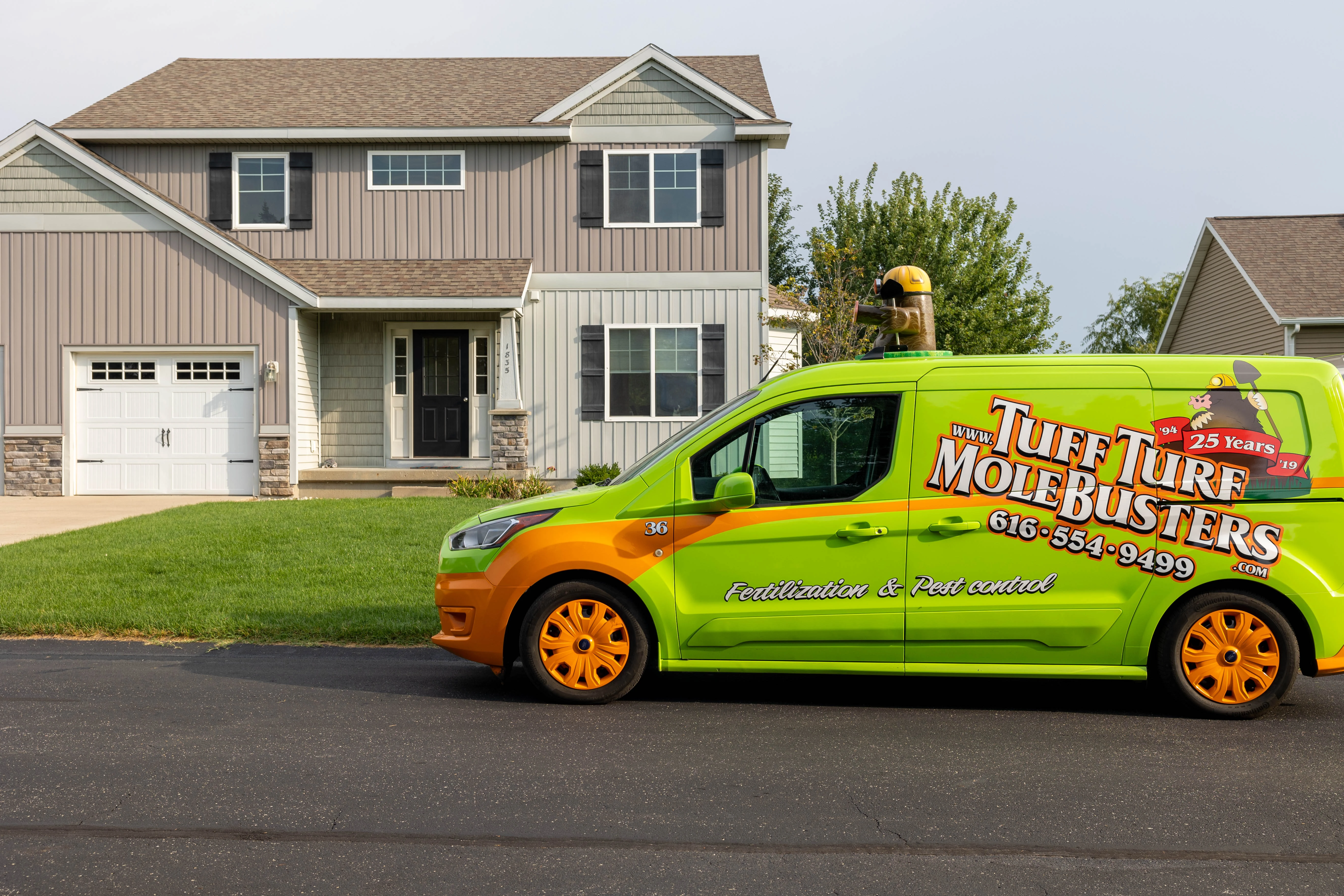 Tuff Turf Mole Busters vehicle parked in front of a home in Grand Rapids, MI